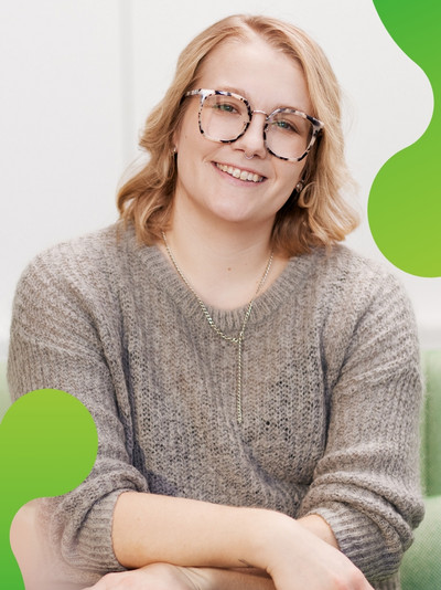 Eine Frau schaut zufrieden in die Kamera und lacht