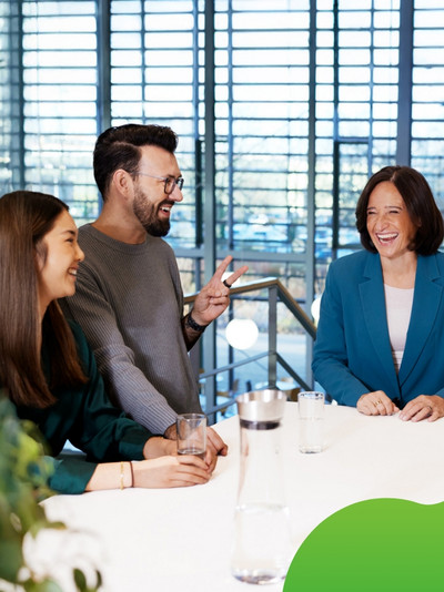 Drei Personen unterhalten sich angeregt und lachen. 