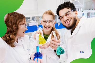 Drei junge Personen in einem Labor die lachen und Reagenzgläser in der Hand halten.