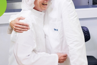 Zwei Mitarbeitende einer pharmazeutischen Produktion, die miteinander sprechen. 