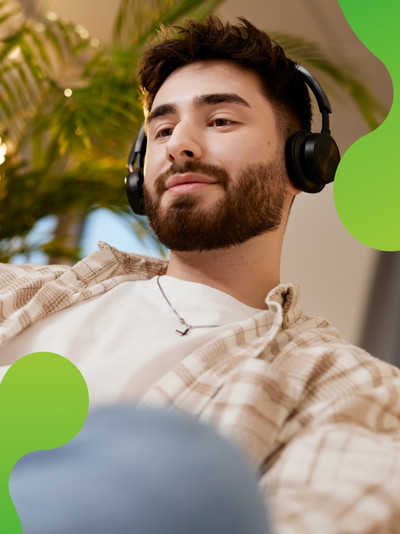 Junger Mensch, der in einer lockeren Atmosphäre an einem Computer arbeitet. 