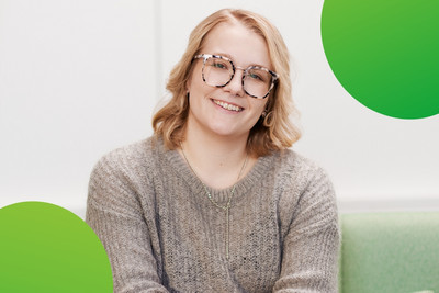 Eine Frau schaut zufrieden in die Kamera und lacht