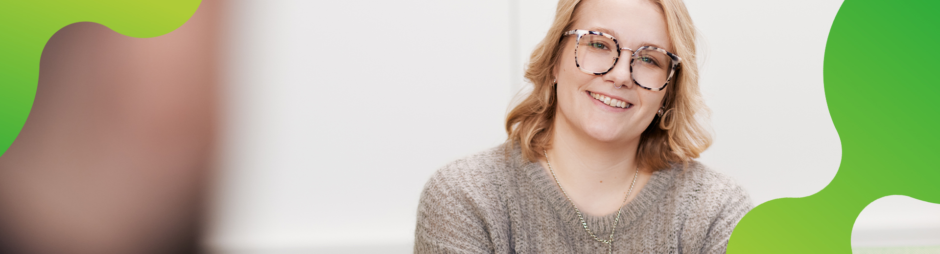 Eine Frau schaut zufrieden in die Kamera und lacht