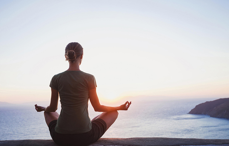 Meditierende Frau am Meer