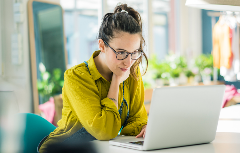 Eine Frau sitzt am Laptop und verfasst einen aufklärenden Artikel gegen das Stigma der Schizophrenie