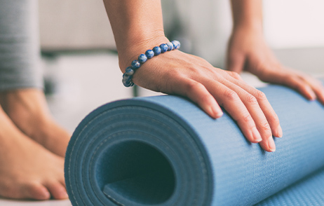 Frau rollt Yogamatte aus