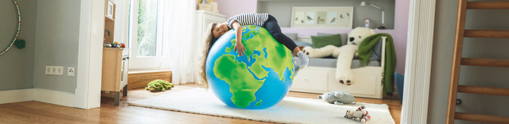 Ein Kind liegt auf einer Weltkugel