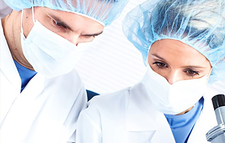 Chemiker mit Glaskolben am Mikroskop