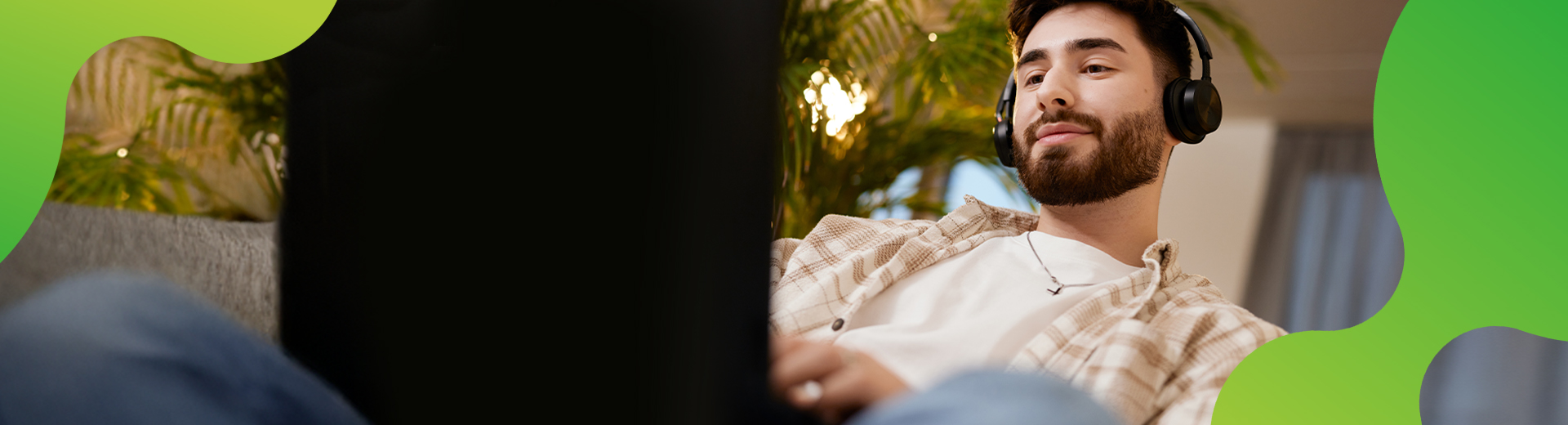 Junger Mensch, der in einer lockeren Atmosphäre an einem Computer arbeitet. 