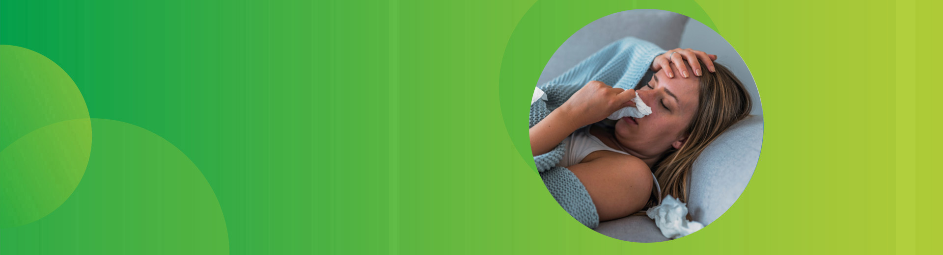 Frau liegt auf dem Sofa und schneuzt sich die Nase