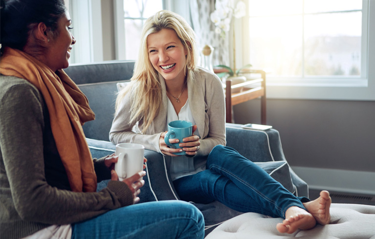 Eine Frau und ihre Freundin trinken Kaffee zusammen und unterstützen sich gegenseitig bei Fragen zur psychischen Gesundheit