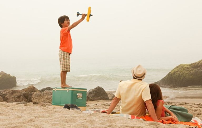 Familie am Strand, Kind spielend