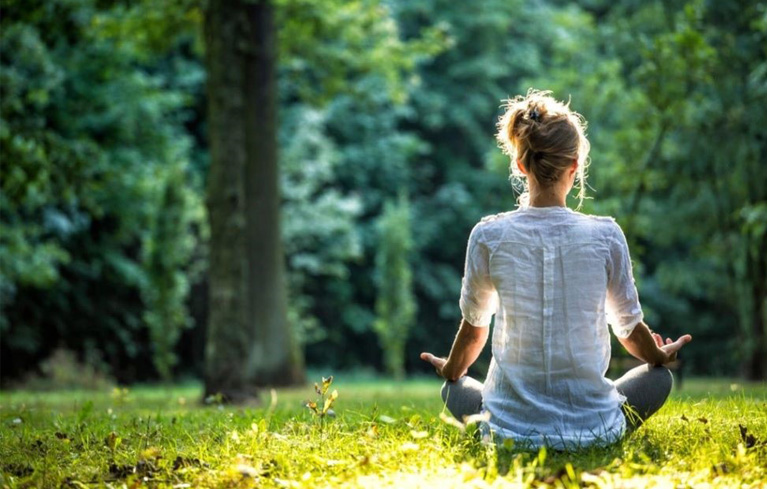 Junge Frau im Wald, meditierend