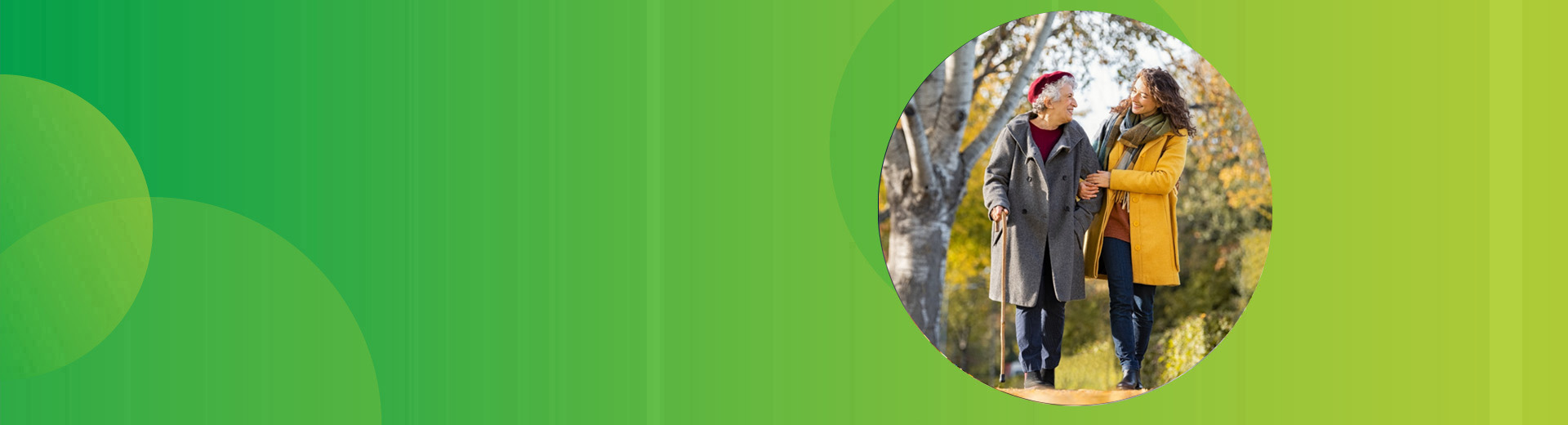 Eine Tochter geht Arm in Arm eingehakt mit ihrer pflegebedürftigen Mutter im Park spazieren